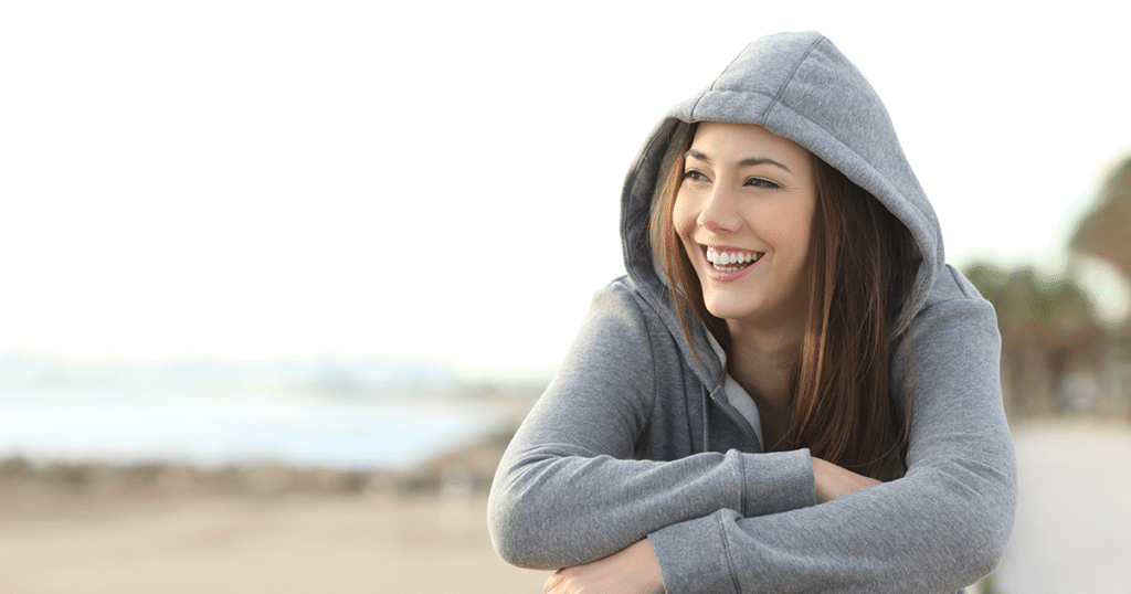 Woman smiling wearing hoodie.