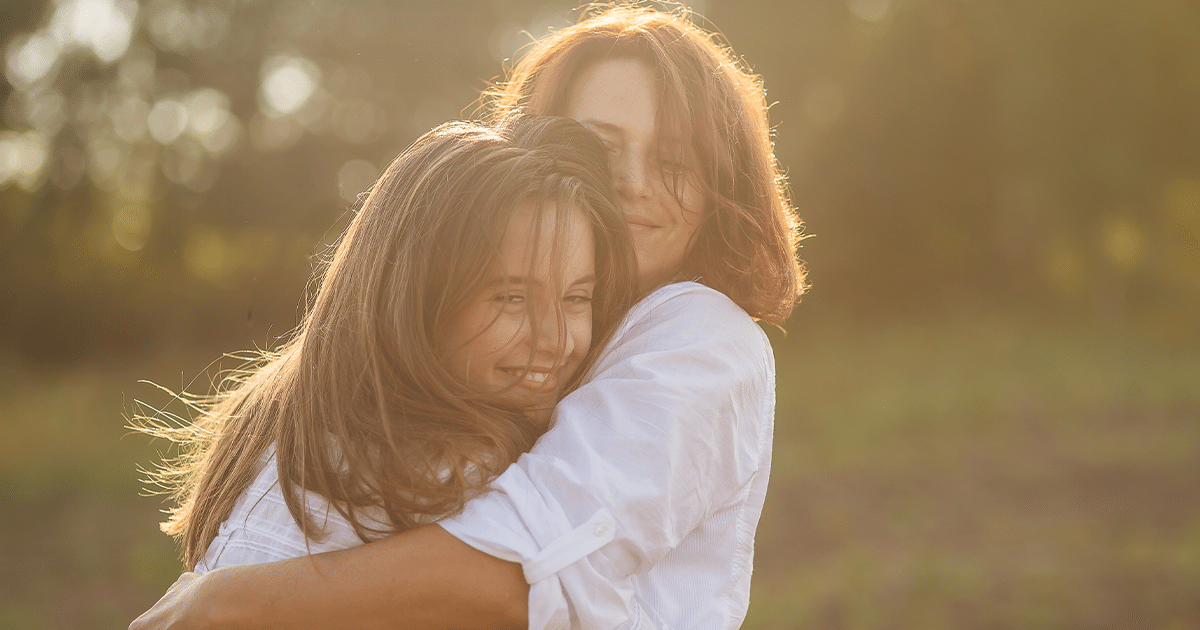 Woman hugging teenager.