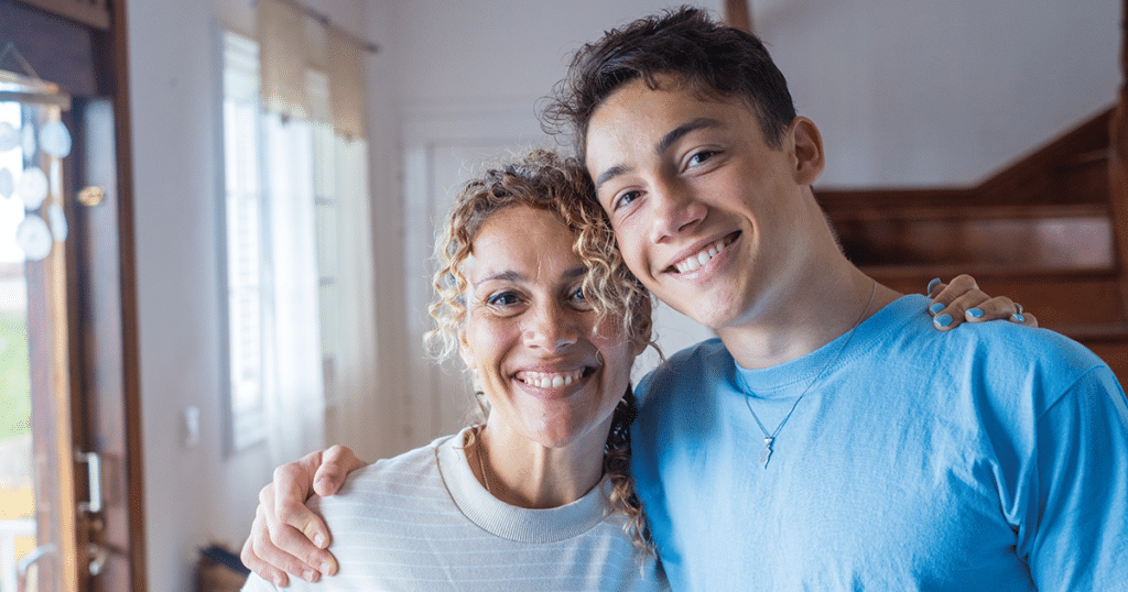 Mom and son smiling and hugging.